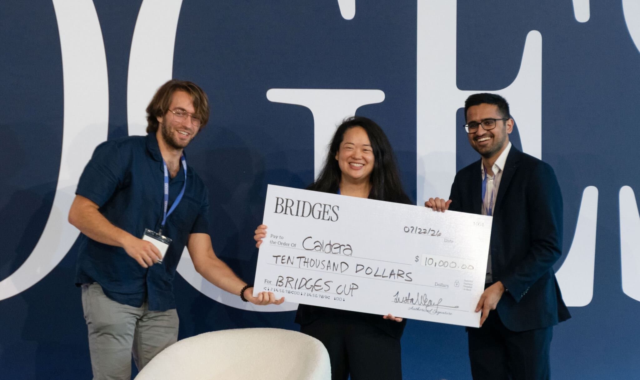 Starbridge CEO Justin Wenig presents the BRIDGES Cup to the Caldera team on stage in New York.